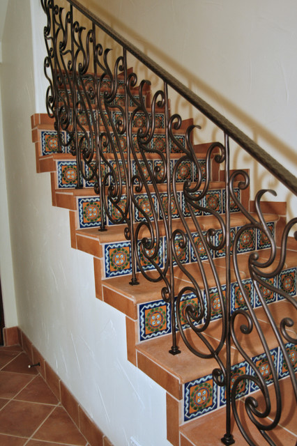 Фотография лестницы с коваными перилами.