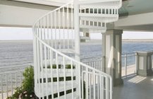 Дизайн винтовой лестницы в белых тонах.