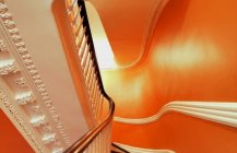 Современный дизайн лестницы в оранжевых сполохах.