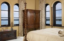 Современный дизайн спальни с множеством окон